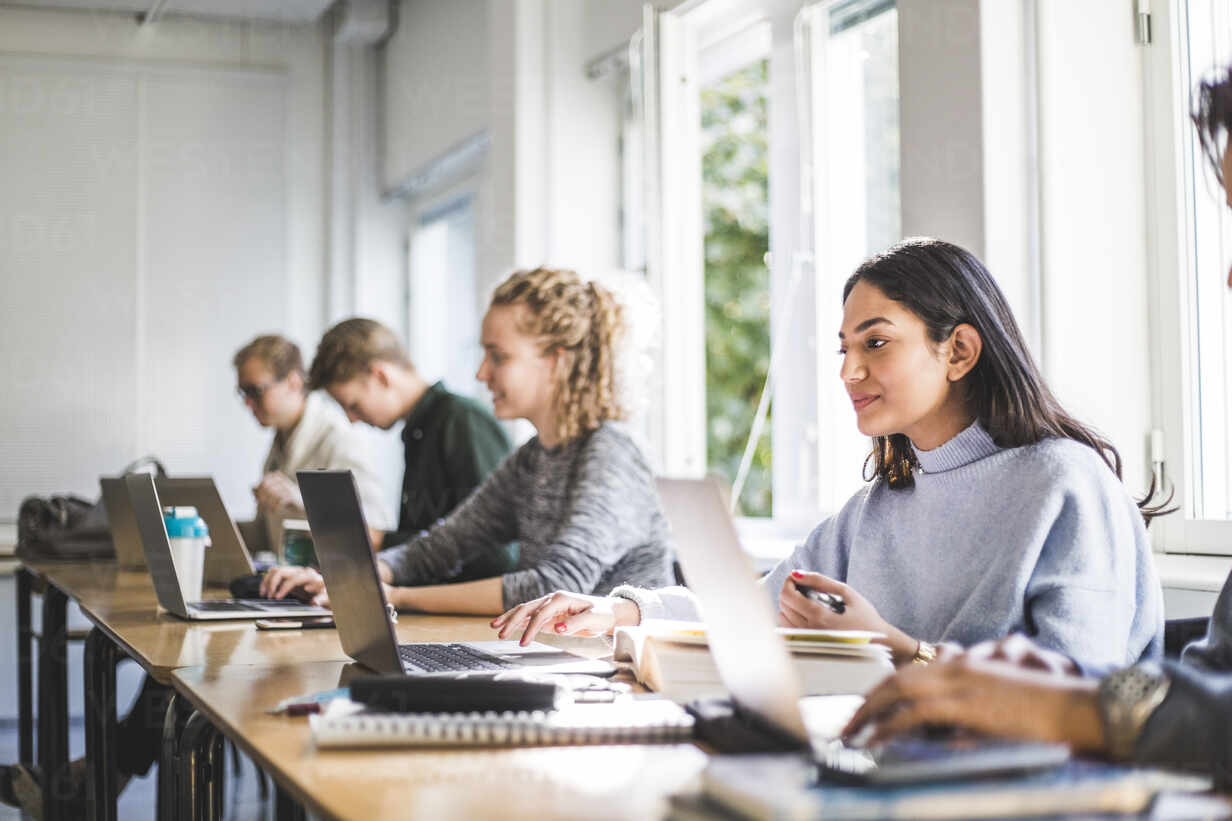 Studenter använder bärbara datorer under seminarium