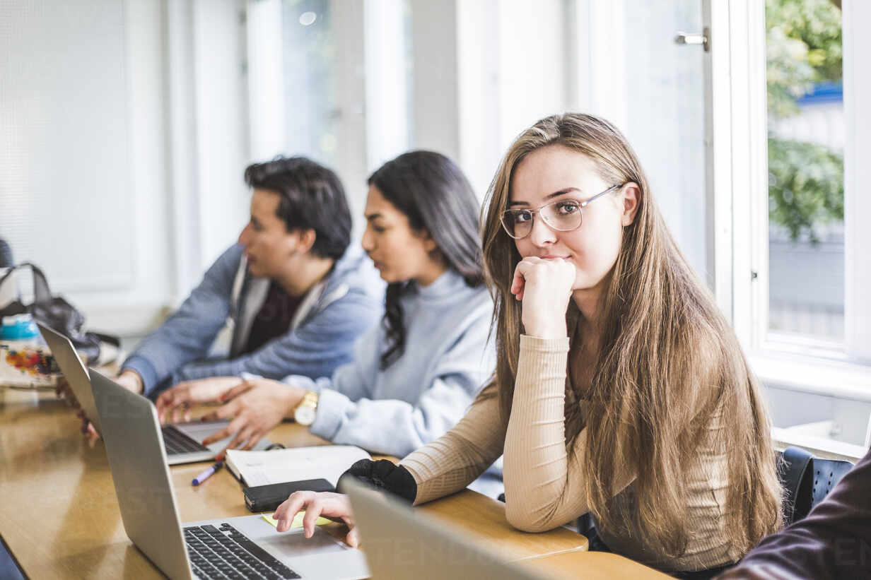 Porträtt av fokuserad kvinnlig student i seminarierum